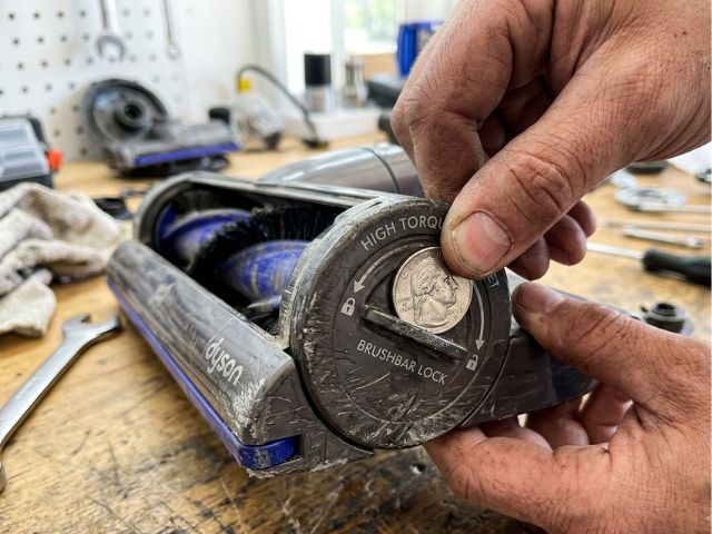 Using a silver US quarter coin to unlock the side cap of a high torque vacuum cleaner attachment when the dyson v11 floor head brush not spinning